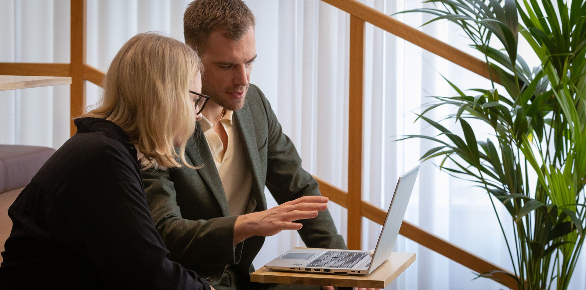Foto på en man och en kvinna som sitter och tittar på en laptopskärm